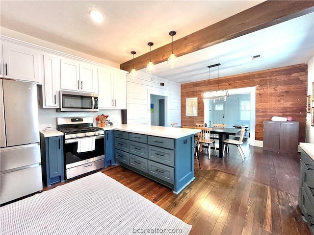 708 E 27th St E, Bryan, TX 77803 - kitchen with white cabinets, dark hardwood / wood-style floors, appliances with stainless steel finishes, decorative light fixtures, and kitchen peninsula