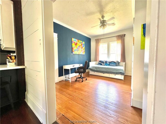 708 E 27th St E, Bryan, TX 77803 - bedroom with wood-type flooring, a textured ceiling, ceiling fan, and crown molding
