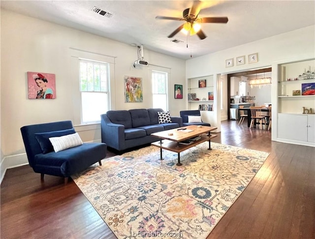 living room featuring ceiling fan, dark hardwood / wood-style flooring, and built in features