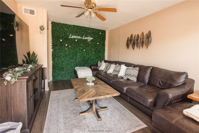 living room with ceiling fan and dark wood-type flooring