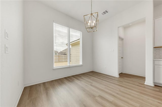 unfurnished dining area featuring a notable chandelier and light hardwood / wood-style floors