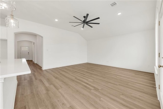 unfurnished living room with ceiling fan, vaulted ceiling, and light hardwood / wood-style flooring