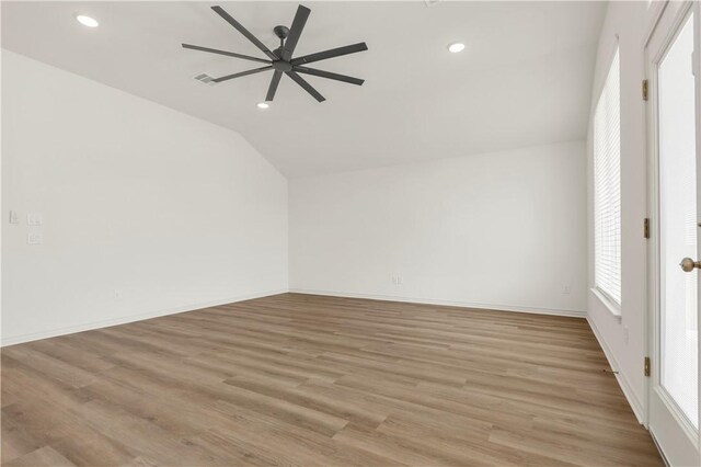 empty room featuring vaulted ceiling, light hardwood / wood-style floors, and ceiling fan