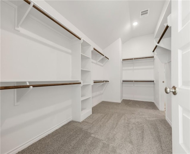 walk in closet featuring lofted ceiling and light colored carpet