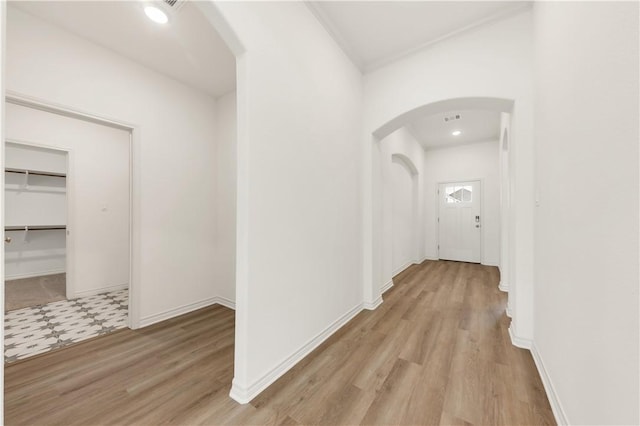 hallway featuring crown molding and light hardwood / wood-style floors