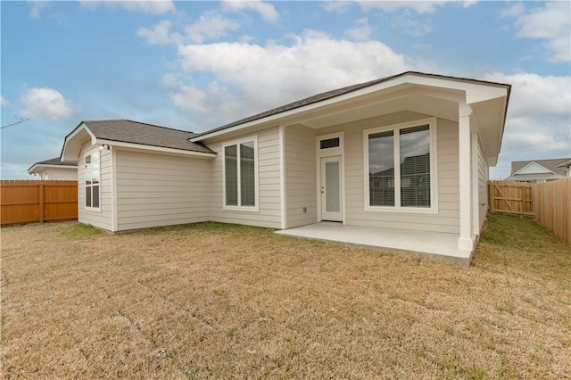 back of house with a patio and a yard