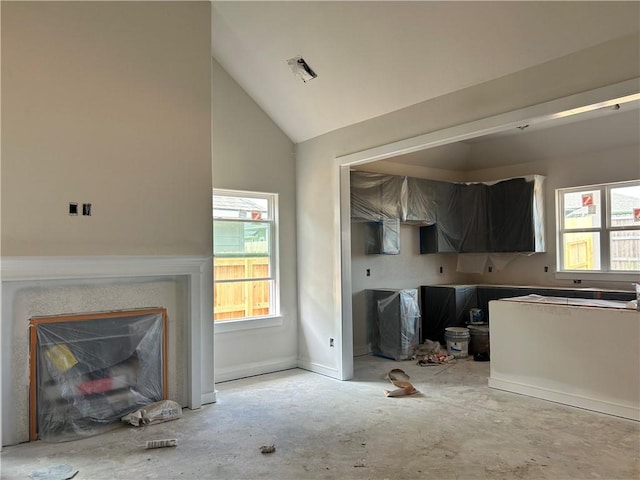 1937 Pinemont View Dr, Bryan, TX 77807 - kitchen featuring vaulted ceiling, a glass covered fireplace, and concrete flooring