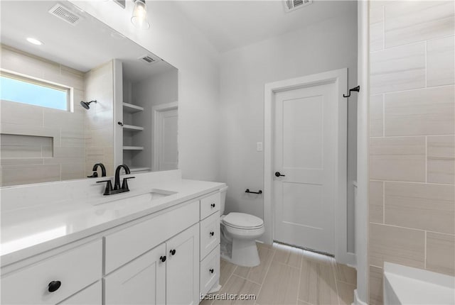 bathroom featuring vanity, toilet, and tiled shower