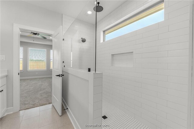 bathroom with plenty of natural light, tiled shower, and vanity