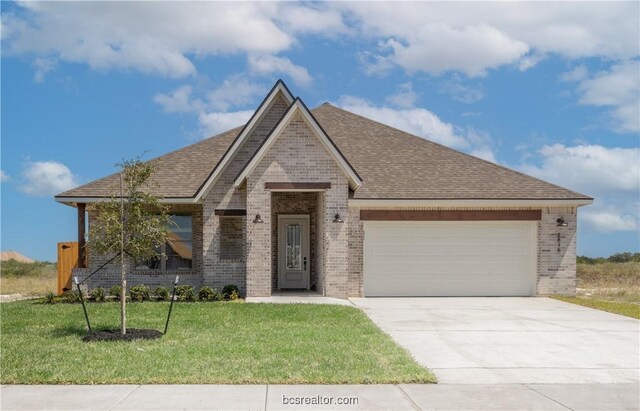 view of front of house featuring a front yard and a garage