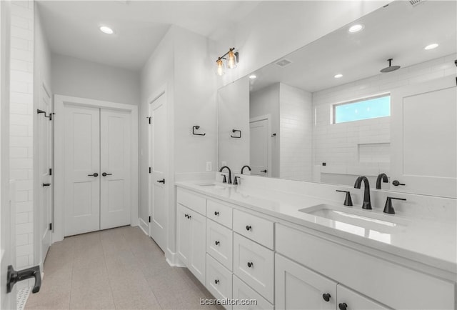 bathroom with tiled shower and vanity