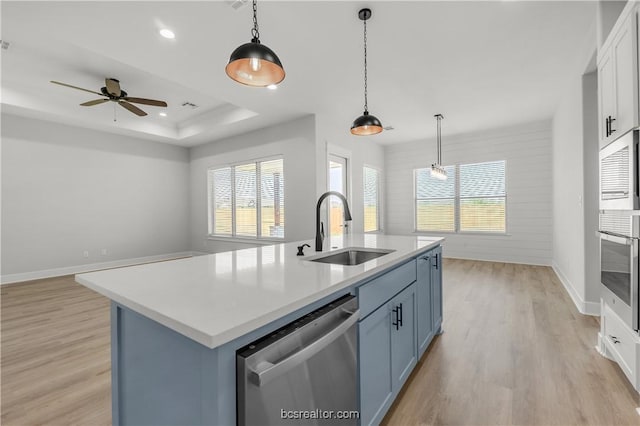 kitchen featuring a wealth of natural light, a kitchen island with sink, sink, and appliances with stainless steel finishes