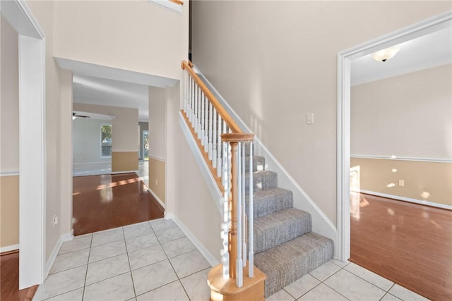 stairs with hardwood / wood-style floors and ceiling fan