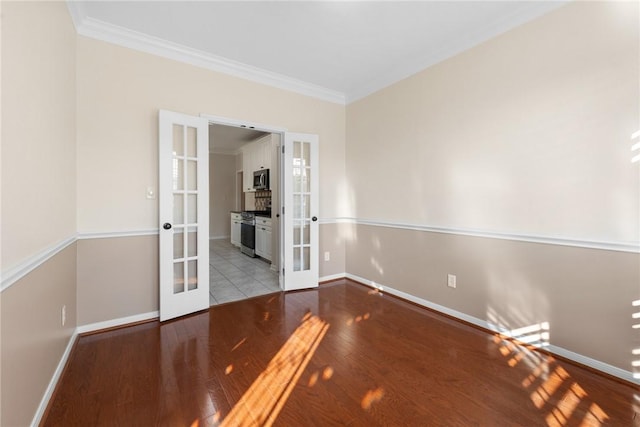 empty room with light wood-type flooring, ornamental molding, and french doors