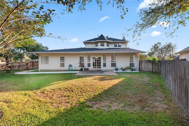 rear view of property with a yard and a patio