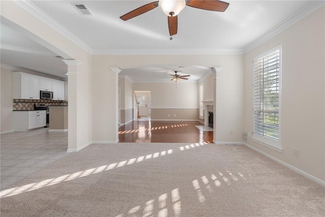 5115 Bellerive Bend Dr, College Station, TX 77845 - unfurnished living room featuring a ceiling fan, light colored carpet, ornamental molding, a fireplace with flush hearth, and ornate columns