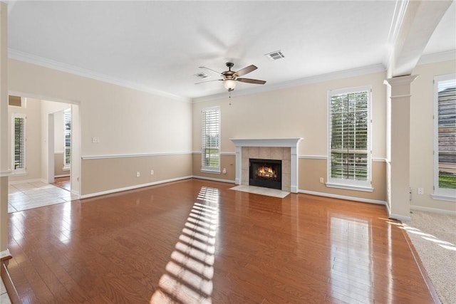 unfurnished living room featuring ceiling fan, light hardwood / wood-style flooring, a healthy amount of sunlight, and ornamental molding