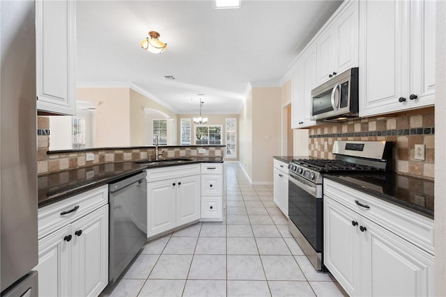 kitchen with decorative backsplash, appliances with stainless steel finishes, sink, light tile patterned floors, and white cabinetry