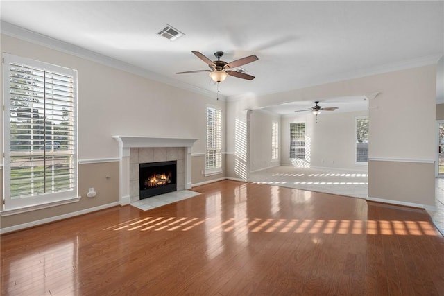 unfurnished living room with light hardwood / wood-style floors, crown molding, and a tile fireplace