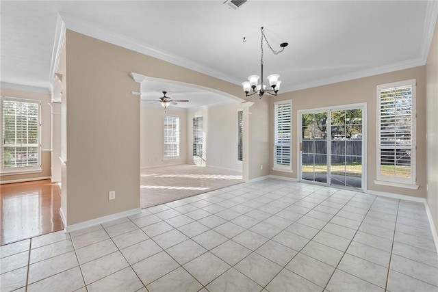 tiled empty room featuring ceiling fan with notable chandelier and crown molding