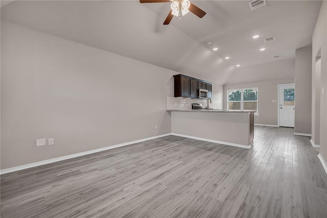 unfurnished living room with light hardwood / wood-style flooring, vaulted ceiling, and ceiling fan