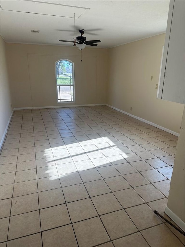 tiled spare room featuring ceiling fan