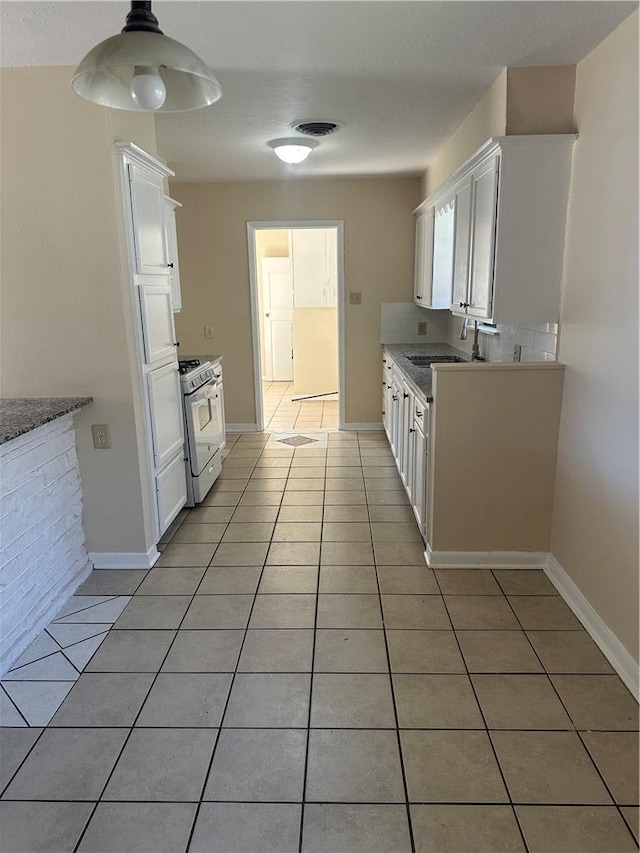 kitchen with white cabinetry, sink, and white gas stove