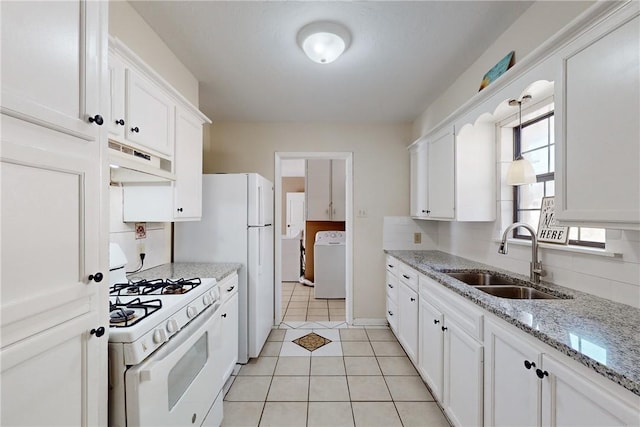 kitchen featuring light tile patterned flooring, washer / dryer, sink, white cabinets, and white appliances