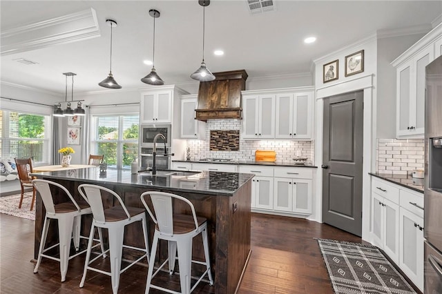 2987 Archer Dr, Bryan, TX 77808 - kitchen featuring built in microwave, a sink, crown molding, stainless steel gas cooktop, and white cabinets