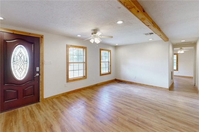 entryway featuring ceiling fan, beam ceiling, light hardwood / wood-style floors, and a textured ceiling