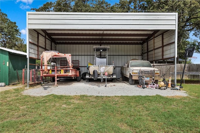 view of outdoor structure with a yard, a carport, and a trampoline