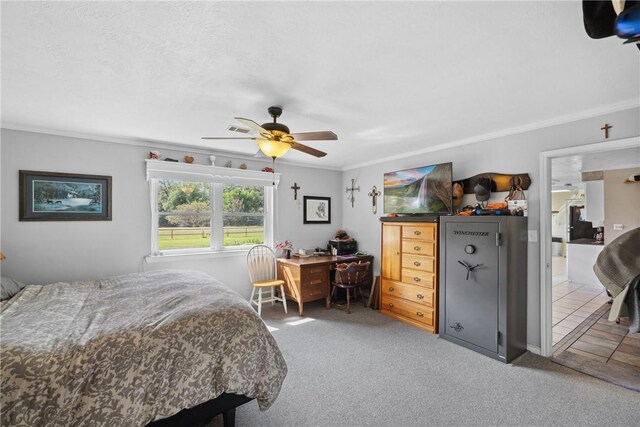 bedroom featuring carpet, ensuite bath, ceiling fan, and ornamental molding