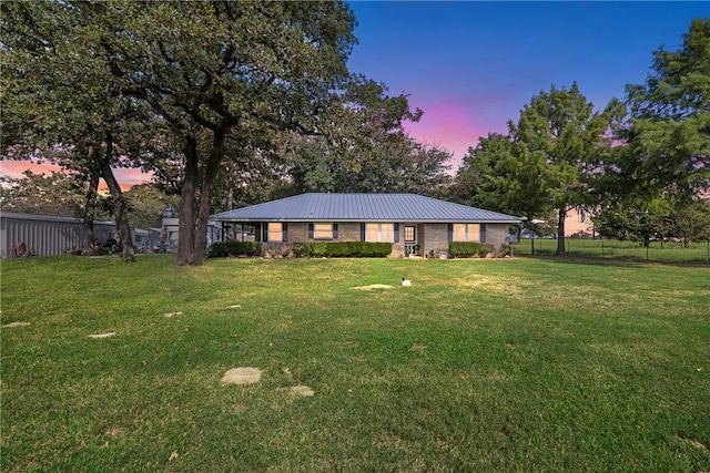 ranch-style home featuring a lawn