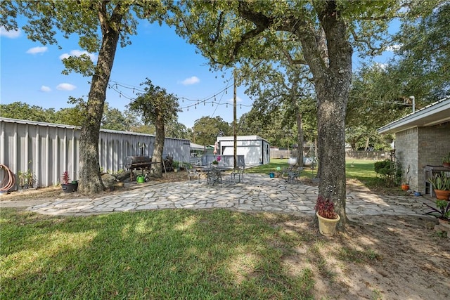 view of yard with a storage unit and a patio