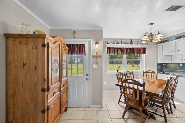 tiled dining room featuring crown molding, a chandelier, and a textured ceiling