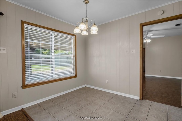 spare room featuring wooden walls, ceiling fan with notable chandelier, ornamental molding, and light tile patterned floors