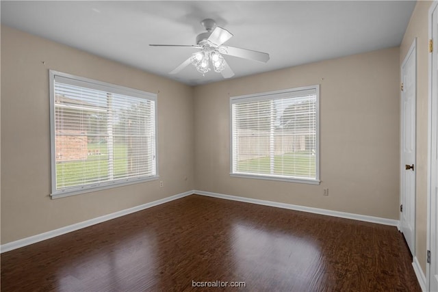 spare room featuring dark wood-type flooring, ceiling fan, and a healthy amount of sunlight