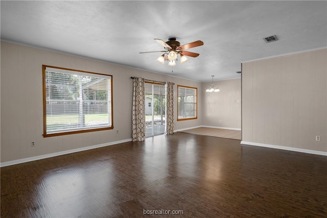 spare room with ceiling fan with notable chandelier, crown molding, and dark wood-type flooring