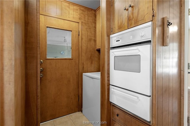 washroom featuring light tile patterned flooring, cabinets, and wooden walls