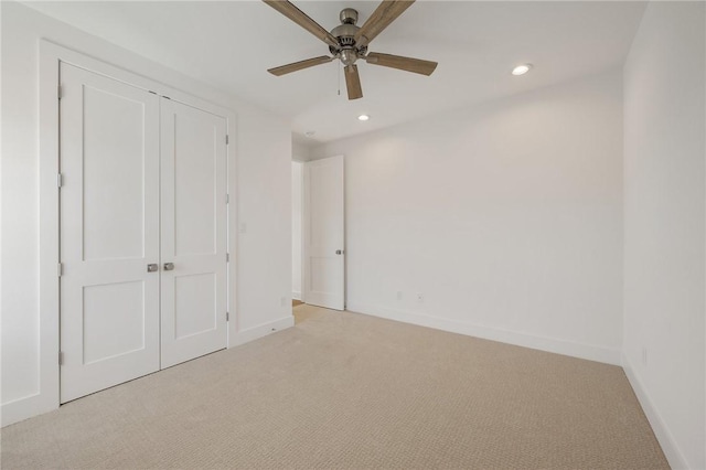 unfurnished bedroom with light carpet, a closet, and ceiling fan