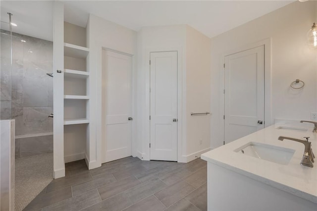 bathroom featuring a tile shower and vanity