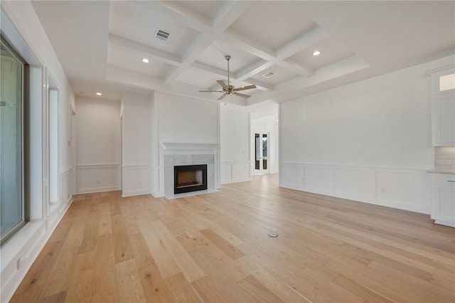 unfurnished living room featuring coffered ceiling, beam ceiling, ceiling fan, and light wood-type flooring