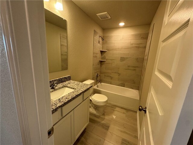 full bathroom featuring vanity, toilet, and tiled shower / bath