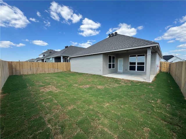 rear view of house with a yard and a patio