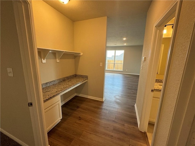 hallway featuring a textured ceiling and dark hardwood / wood-style floors