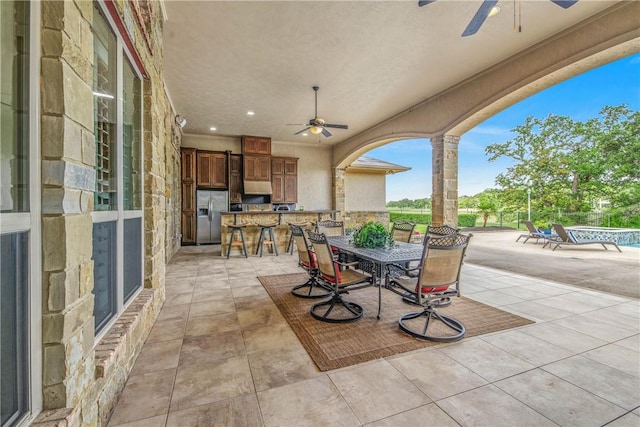 4920 Whistling Straits Loop, College Station, TX 77845 - view of patio / terrace with an outdoor kitchen, a ceiling fan, outdoor dining area, and a swimming pool