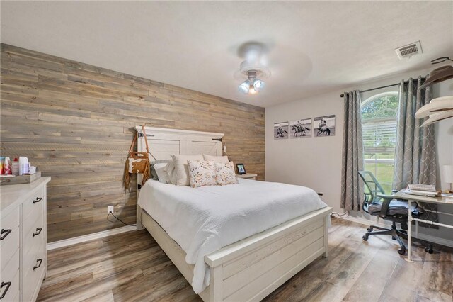 7314 Dilly Shaw Tap Rd, Bryan, TX 77808 - bedroom with wooden walls, light wood-style flooring, baseboards, and a ceiling fan