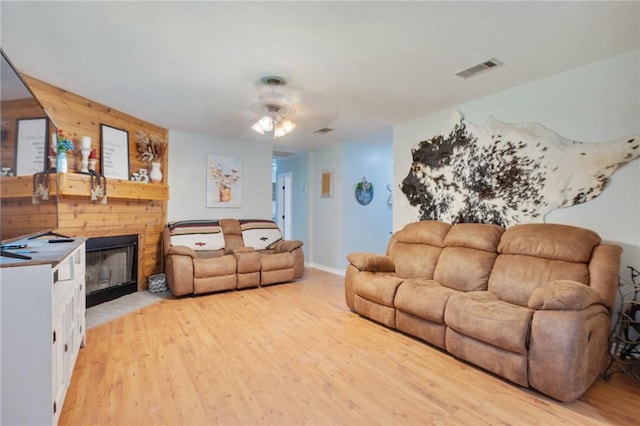 7314 Dilly Shaw Tap Rd, Bryan, TX 77808 - living area featuring a ceiling fan, light wood-type flooring, and a fireplace with flush hearth