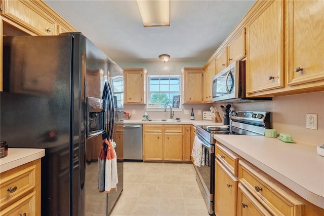 7314 Dilly Shaw Tap Rd, Bryan, TX 77808 - kitchen with stainless steel appliances, light brown cabinetry, a sink, and light countertops