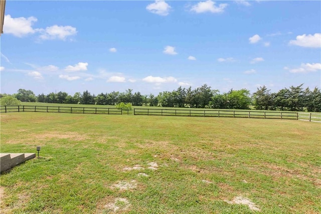 view of yard featuring a rural view and fence